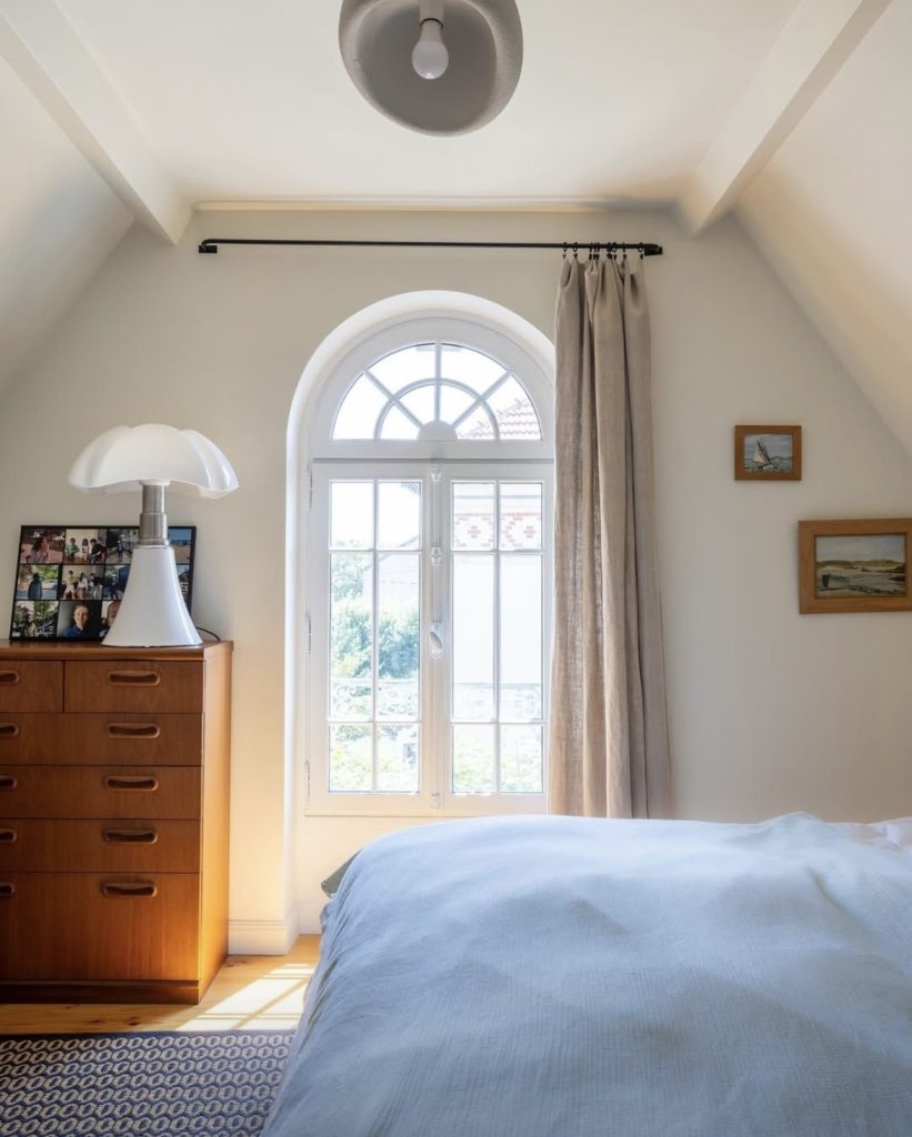 Après rénovation : chambre lumineuse avec fenêtre en arc restaurée